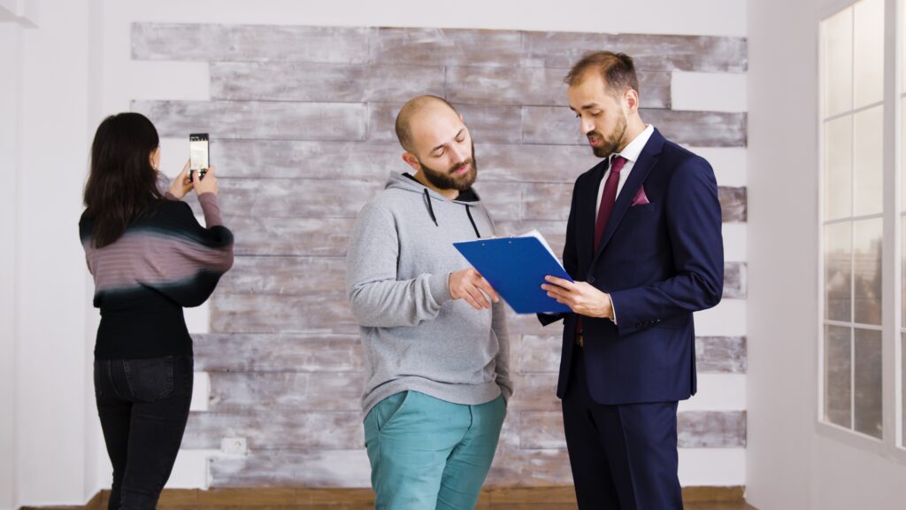 Real estate agent talking with client in empty apartment